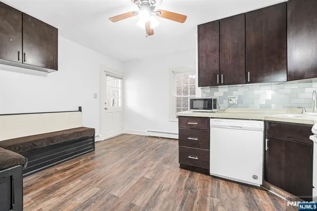 a kitchen with wooden floors and wooden cabinets