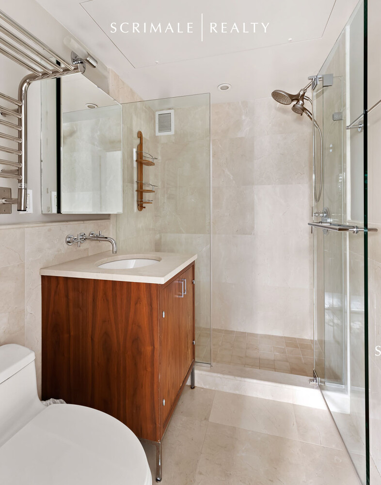 200 East 66th Street, Unit C402 Manhattan, NY 10065 - Photo 6 of 15 a bathroom with a sink a toilet and shower
