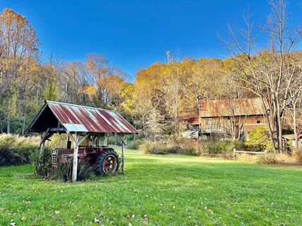 a barn with a wooden fence next to a road