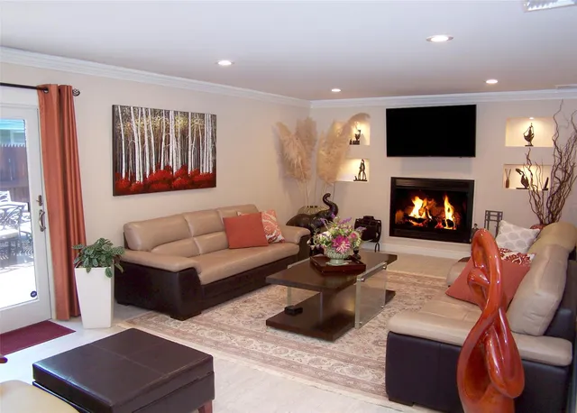 a living room with furniture a fireplace and a flat screen tv
