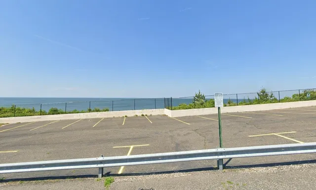 a view of a road with yard and large trees