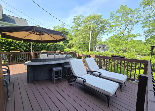 a balcony with wooden floor table and chairs