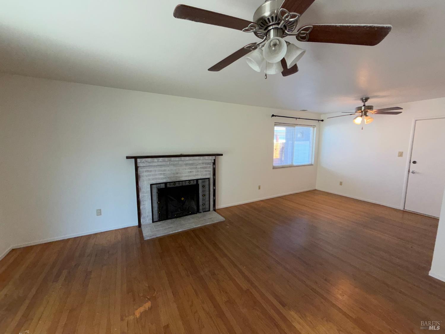 991 Rolling Green Drive Rio Vista, CA 94571 - Photo 12 of 30 an empty room with chandelier fan and wooden floor