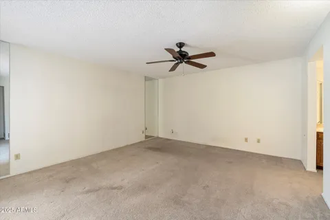 an empty room with a ceiling fan and a window