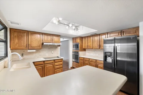 a kitchen with stainless steel appliances granite countertop a refrigerator a sink a stove and island