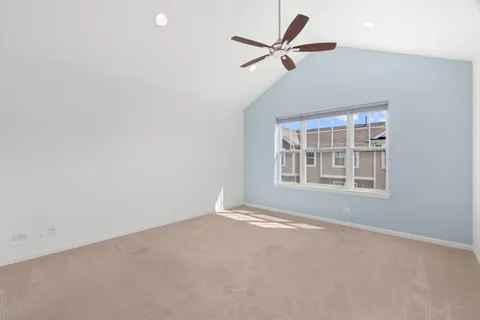 en empty room with windows and ceiling fan