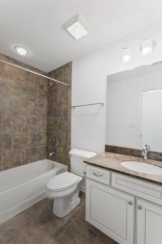 a bathroom with a granite countertop toilet a sink and bathtub