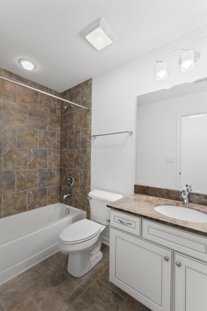 1228 Elm Street Park Ridge, IL 60068 - Photo 23 of 36 a bathroom with a granite countertop toilet a sink and bathtub