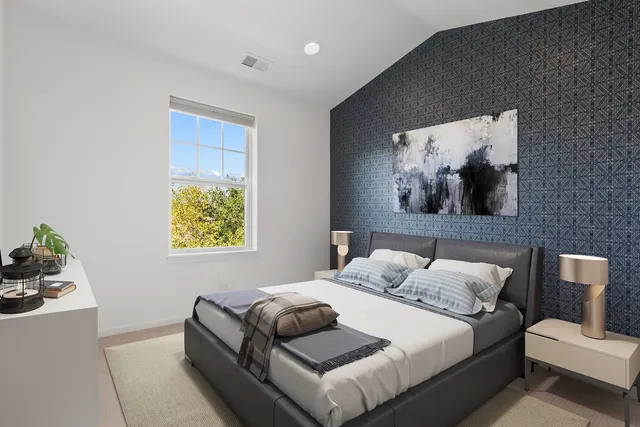 a bedroom with a bed and painting on the wall