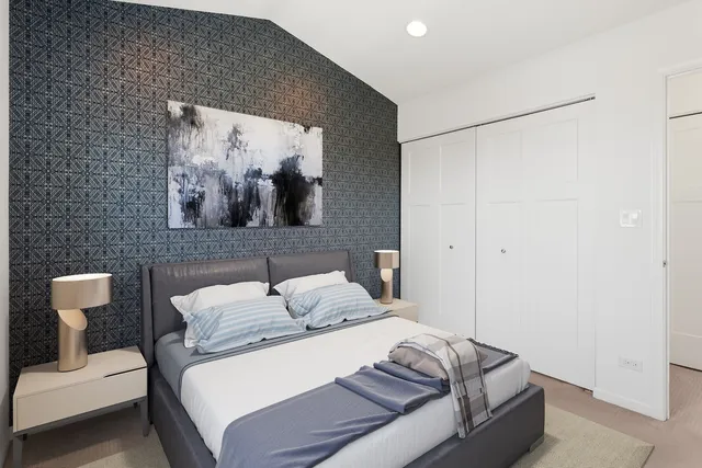 a bedroom with a bed and a painting on the wall