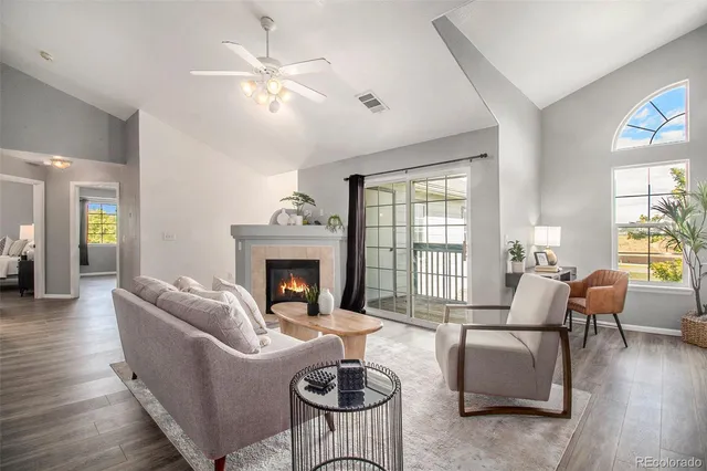 a living room with furniture a fireplace and a large window
