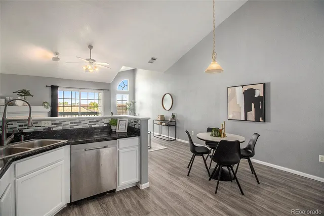 a kitchen with granite countertop white cabinets and chairs