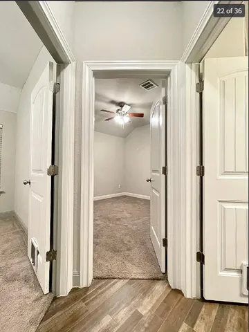 a view of a hallway with wooden floor and staircase
