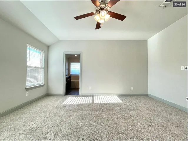 an empty room with windows and fan