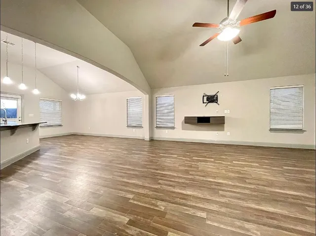 a view of a room with kitchen appliances and a ceiling fan