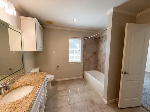 a bathroom with a granite countertop sink a mirror and a bathtub