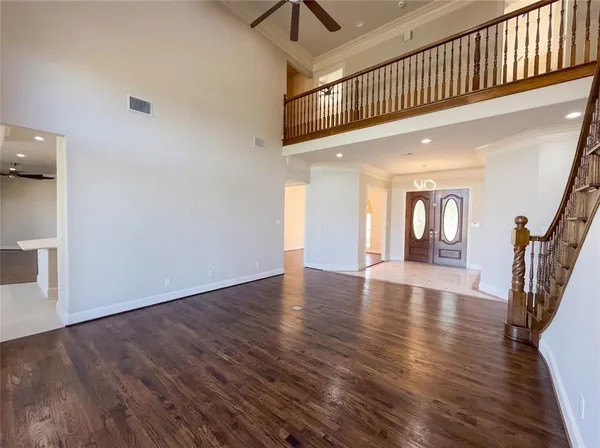 a hallway with wooden floor table and chairs
