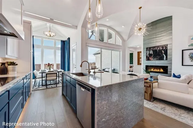 a large white kitchen with a large island oven a stove a sink a dining table and chairs