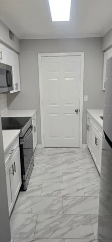a view with granite countertop white cabinets and a sink