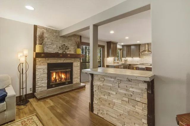 a open kitchen with granite countertop a stove top oven a sink and a fireplace