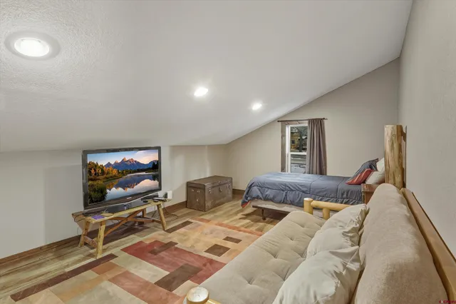 a living room with furniture a flat screen tv and floor to ceiling window