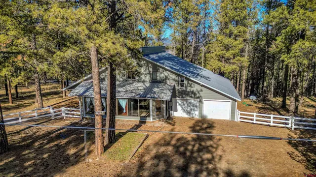 a view of a house with a large tree and wooden fence