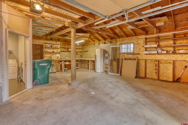 a view of a garage with wooden table and chairs