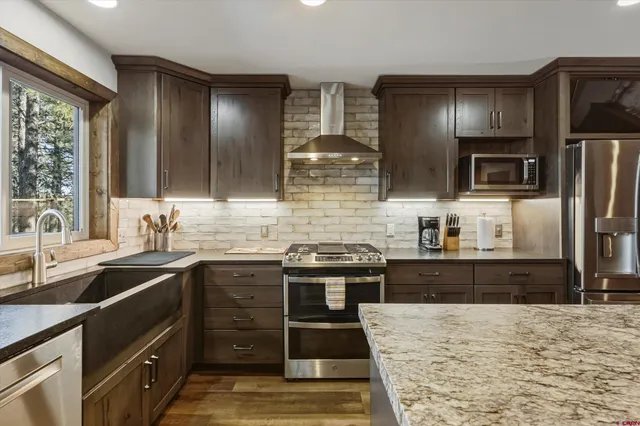 a kitchen with stainless steel appliances a stove a sink and a refrigerator