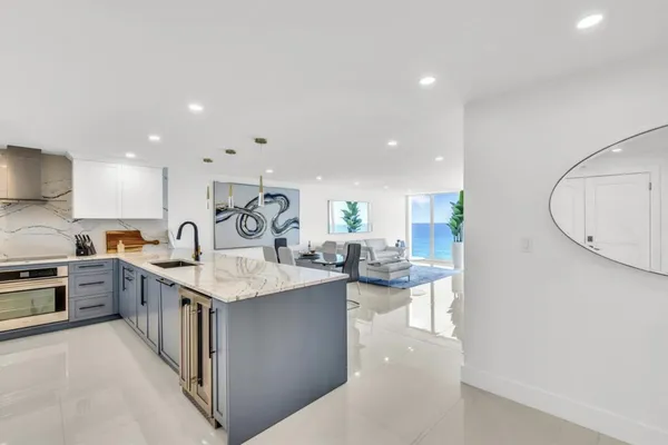 a large kitchen with granite countertop a sink a stove and cabinets