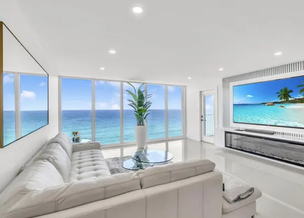 a living room with furniture potted plant and a large window