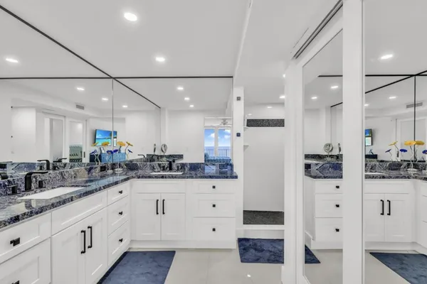 a large white kitchen with stainless steel appliances and white cabinets