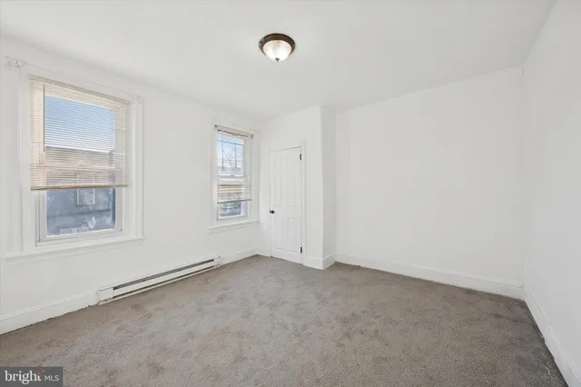 an empty room with windows and closet
