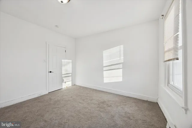 an empty room with windows and closet
