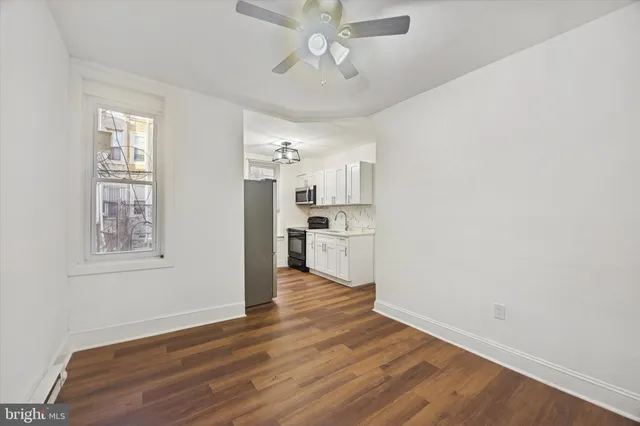 a view of a kitchen with wooden floor and a window