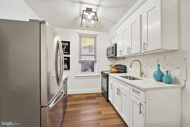 a kitchen with white cabinets and appliances