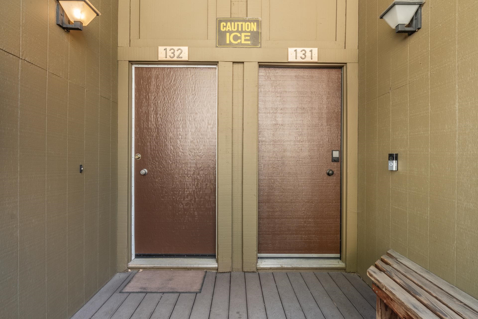 94 John Muir Road, Unit 132 Mammoth Lakes, CA 93546 - Photo 3 of 58 Entryway featuring two textured brown doors with white trim, wood-look flooring, and recessed exterior lighting fixtures