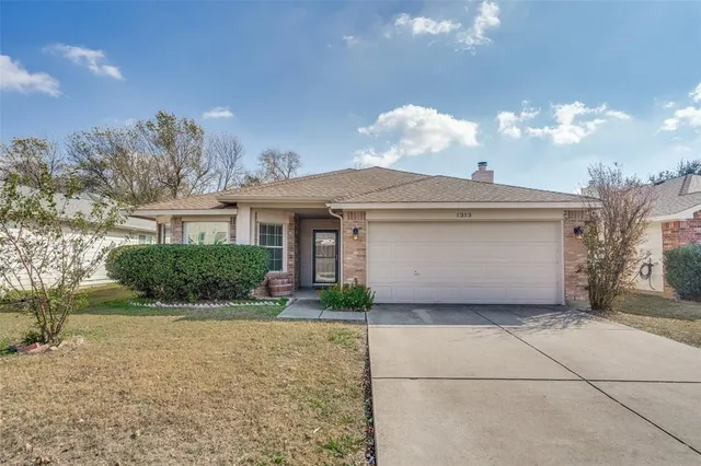 a view of a house with a yard and potted plants