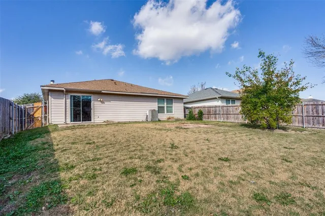 a front view of house with yard and trees around