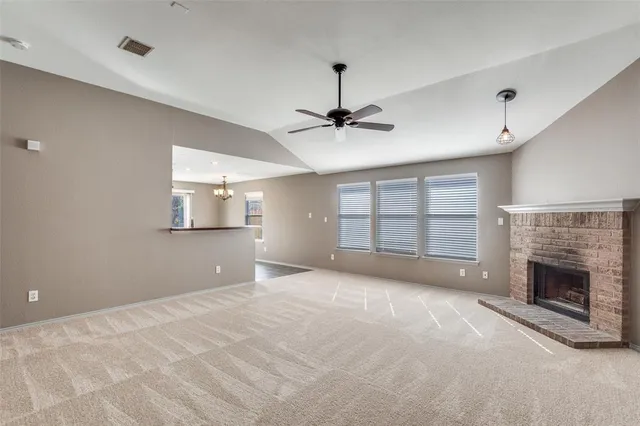 a view of an empty room with a fireplace and a window