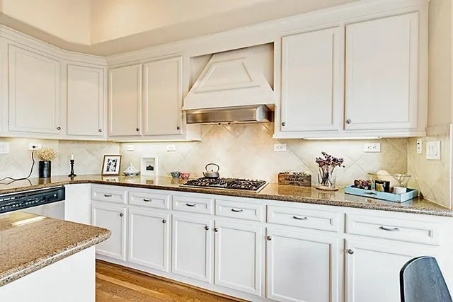 a kitchen with white cabinets and sink
