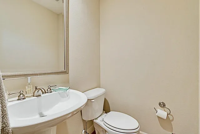 a bathroom with a sink a toilet and mirror