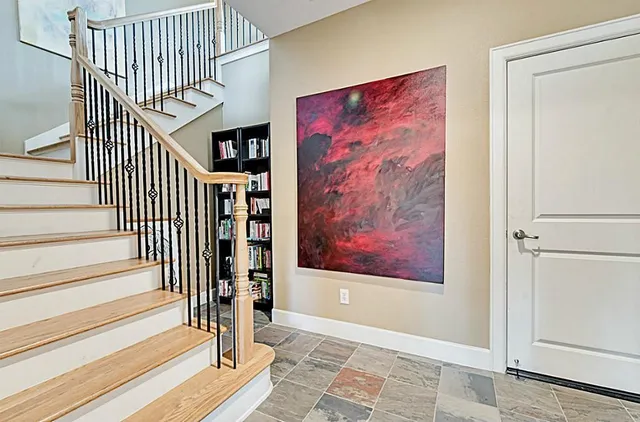 a view of a hallway with wooden floor and entryway