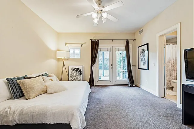 a spacious bedroom with a large bed and a chandelier