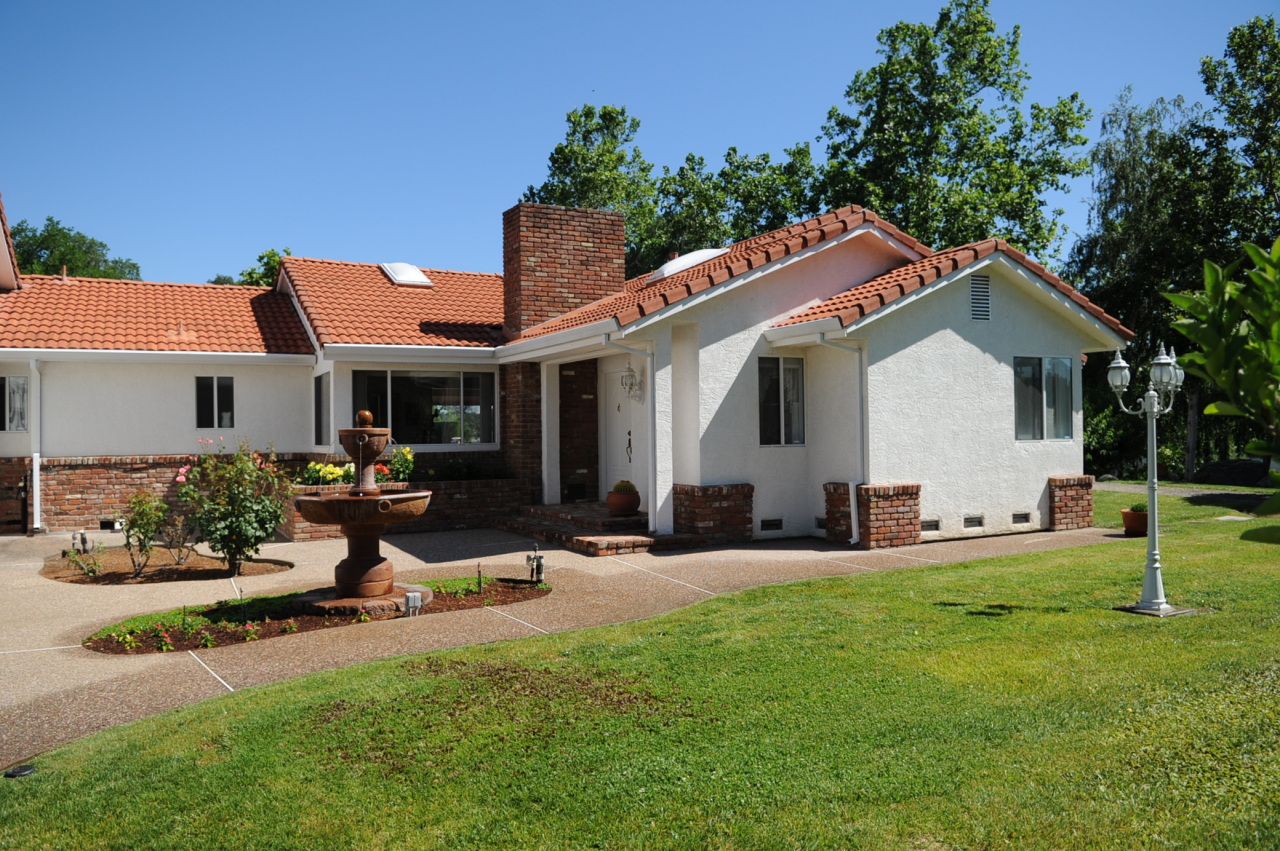 6471 Riverside Drive Redding, CA 96001 - Photo 24 of 56 a front view of a house with a garden and sitting area