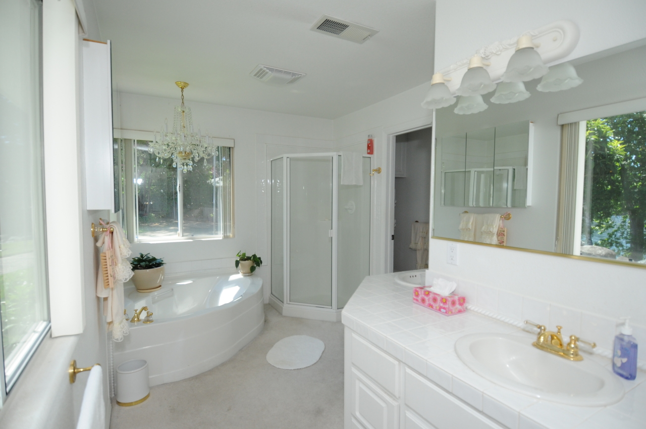 6471 Riverside Drive Redding, CA 96001 - Photo 32 of 56 a bathroom with a sink a large mirror and a shower