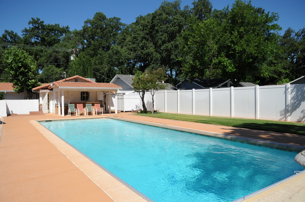 6471 Riverside Drive Redding, CA 96001 - Photo 4 of 56 a front view of a house with swimming pool and a yard