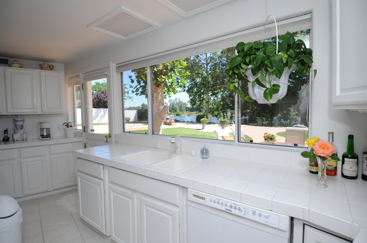 6471 Riverside Drive Redding, CA 96001 - Photo 45 of 56 a kitchen with stainless steel appliances white cabinets a stove and a large window
