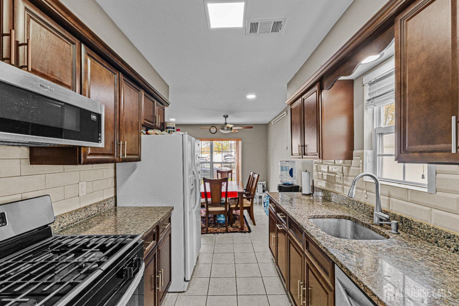 26 Brewster Circle Old Bridge, NJ 08857 - Photo 11 of 43 a kitchen with stainless steel appliances granite countertop a sink stove and refrigerator