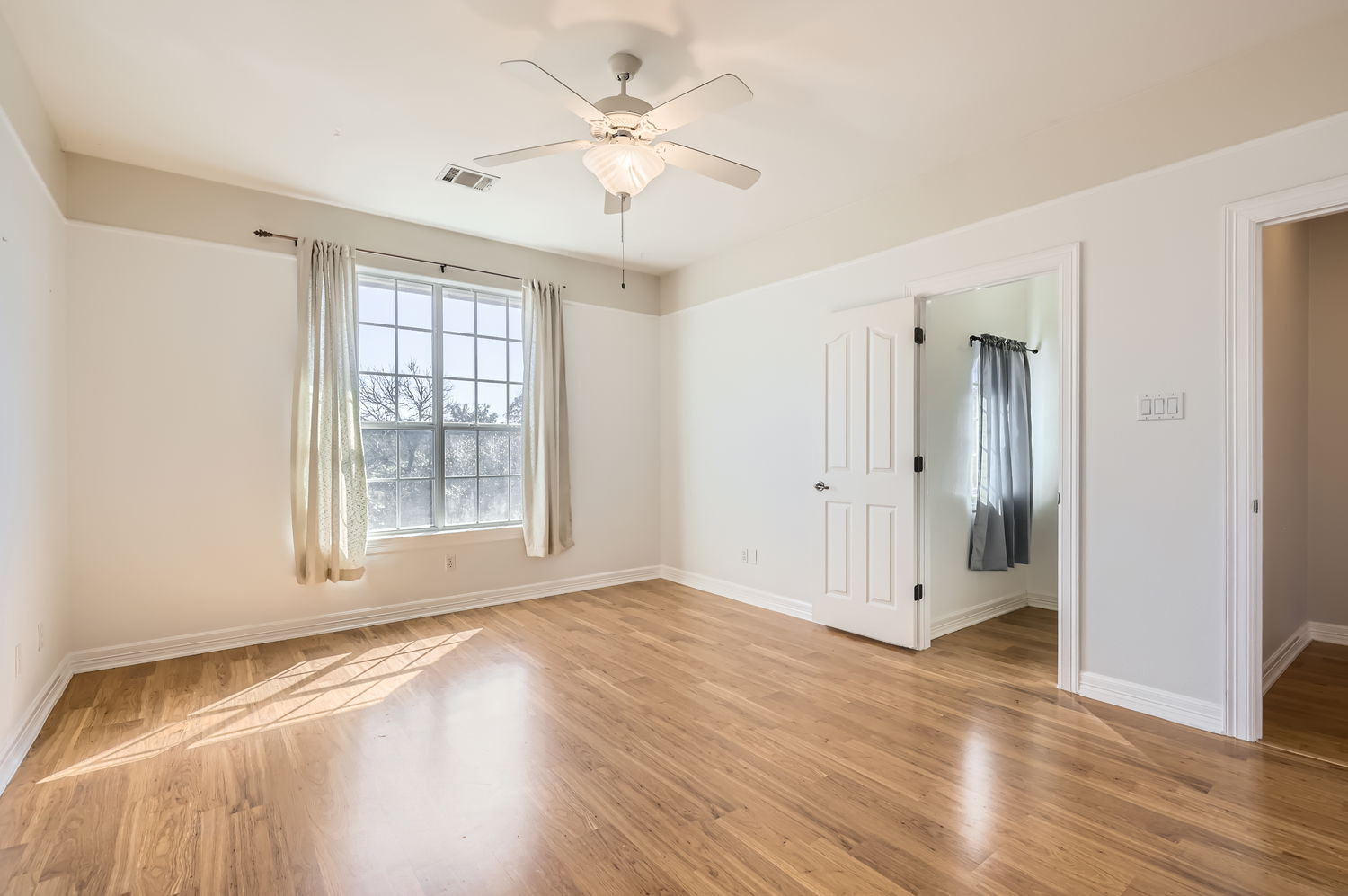 210 Amandas Way Leander, TX 78641 - Photo 22 of 38 Empty room with light wood finished floors, ceiling fan, visible vents, and baseboards