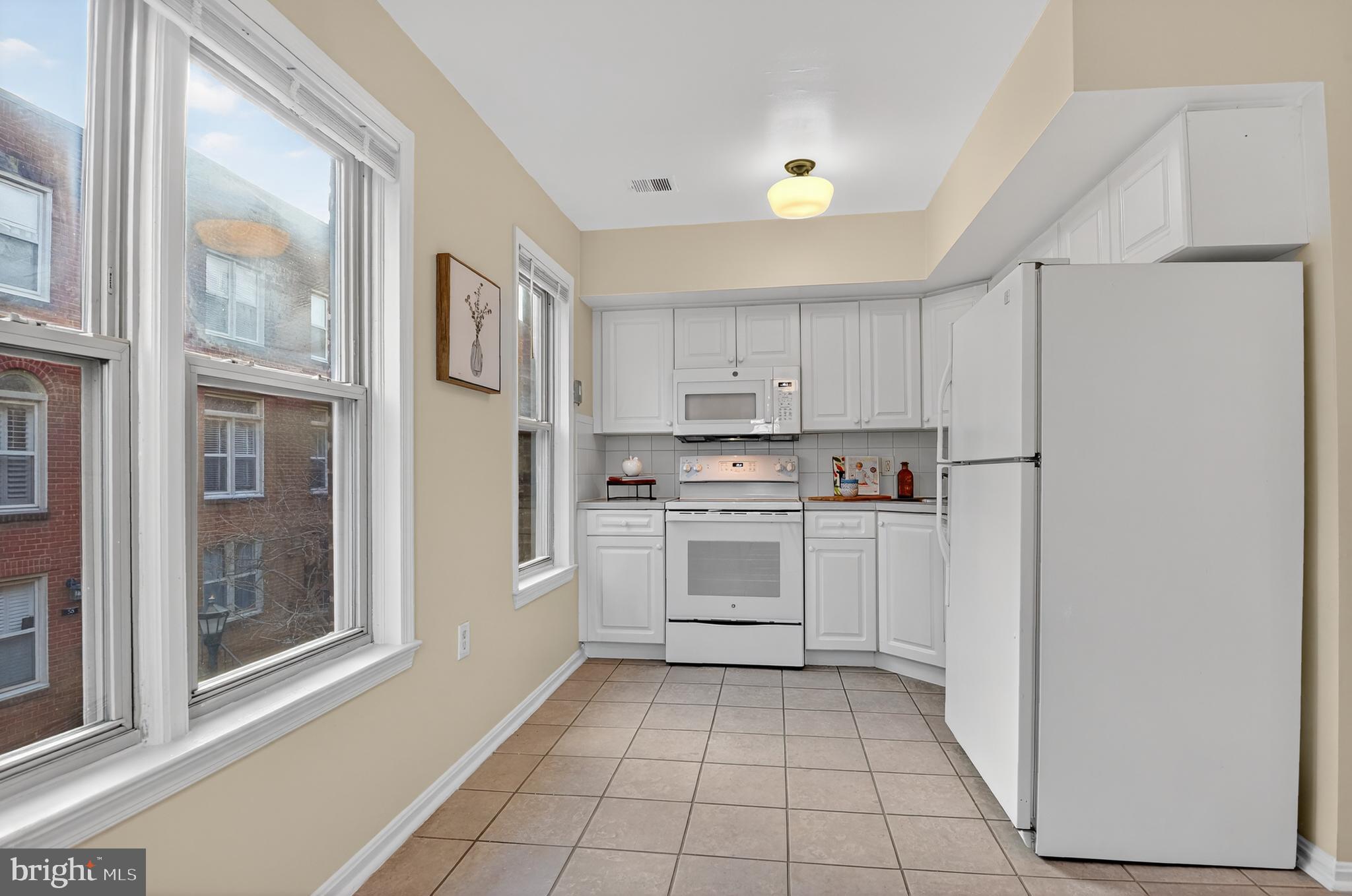 1493 A Street Northeast Washington, DC 20002 - Photo 15 of 31 a kitchen with white cabinets and white appliances